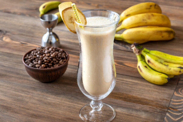 Glass Of Dirty Banana Cocktail With Ingredients On Wooden Background